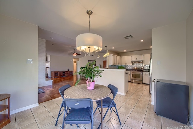 dining space featuring visible vents, ceiling fan, baseboards, and light tile patterned floors