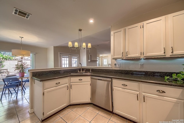 kitchen featuring white cabinets, a sink, decorative light fixtures, and stainless steel dishwasher