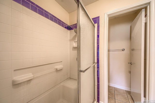 bathroom with a stall shower and tile patterned floors