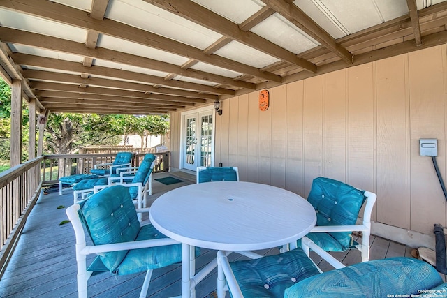 view of patio with outdoor dining space, a wooden deck, and french doors