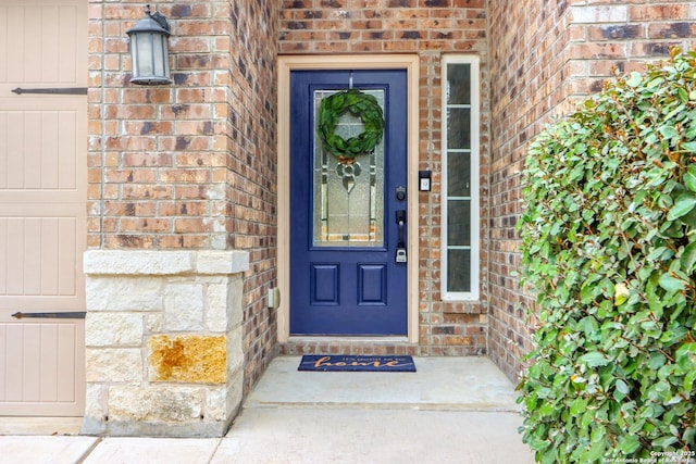 doorway to property featuring brick siding