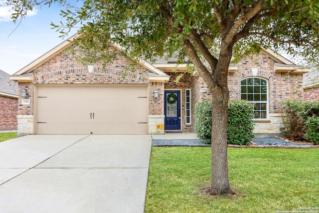 view of front of home featuring a garage, a front yard, brick siding, and driveway