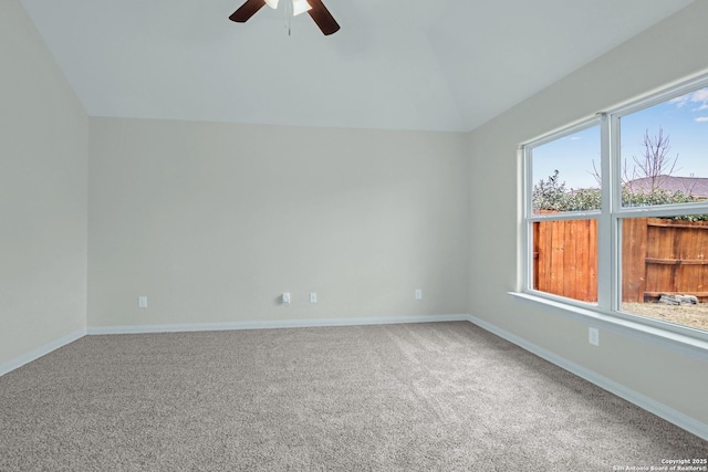 carpeted empty room with lofted ceiling, ceiling fan, and baseboards