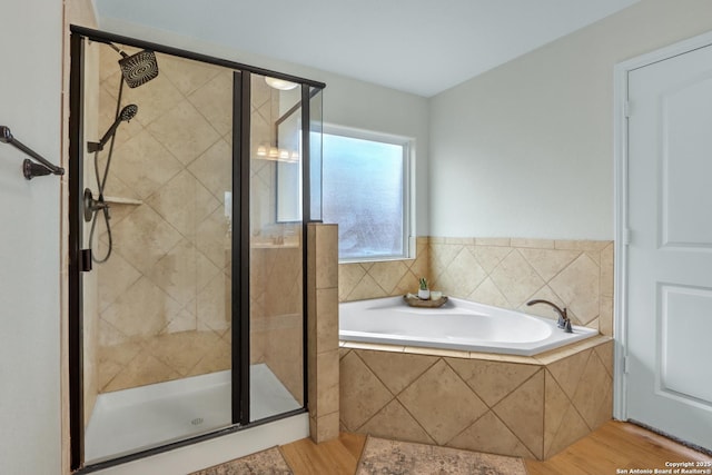 full bathroom with a garden tub, a shower stall, and wood finished floors