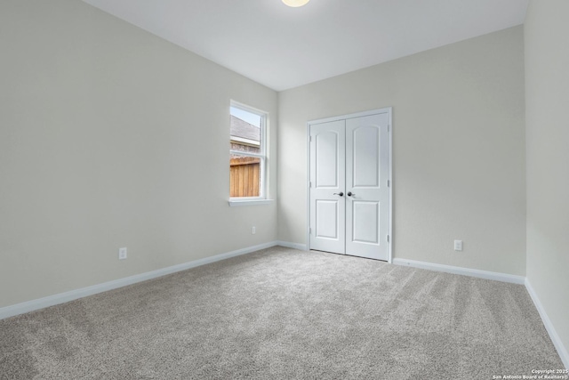 unfurnished bedroom featuring carpet floors, a closet, and baseboards