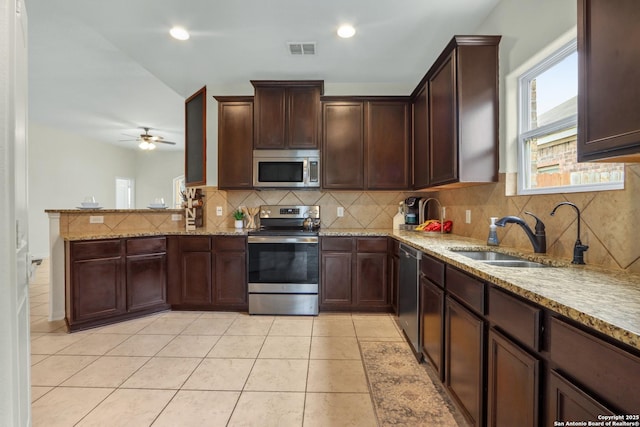 kitchen featuring light tile patterned floors, visible vents, appliances with stainless steel finishes, light stone counters, and a sink