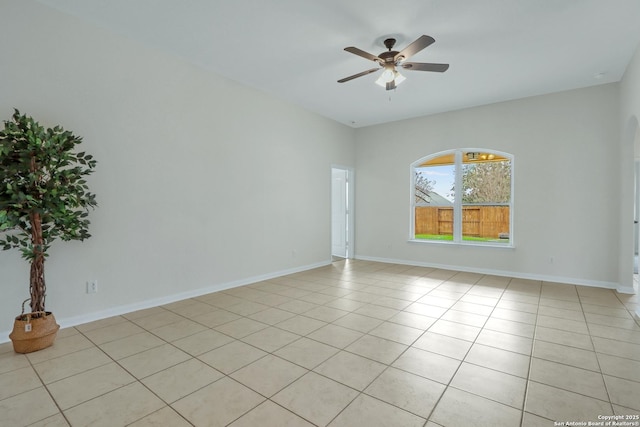 empty room with light tile patterned floors, baseboards, and a ceiling fan