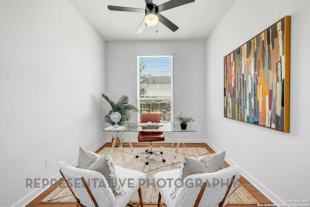 sitting room featuring ceiling fan, baseboards, and wood finished floors