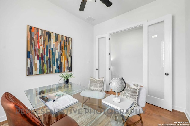 living area with light wood-type flooring, baseboards, visible vents, and a ceiling fan