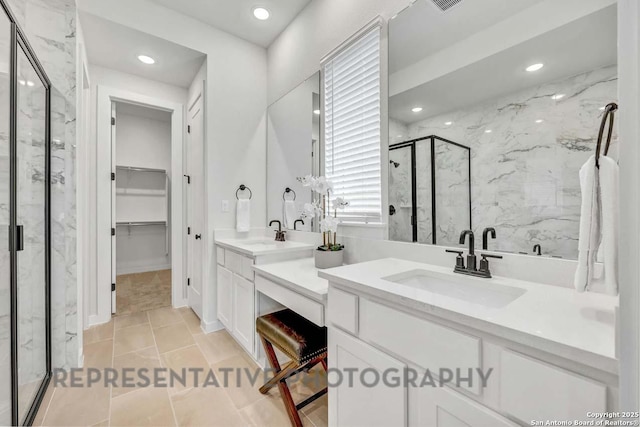 full bathroom with a walk in closet, a marble finish shower, recessed lighting, visible vents, and vanity