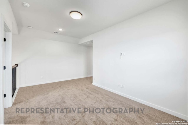 unfurnished room with carpet flooring, visible vents, and baseboards