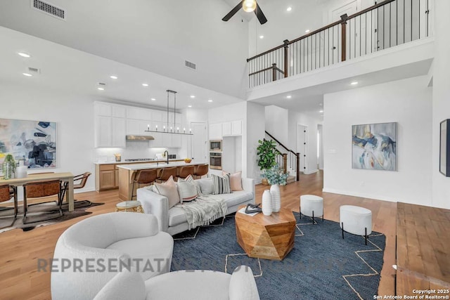 living area with a ceiling fan, recessed lighting, visible vents, and light wood-style floors