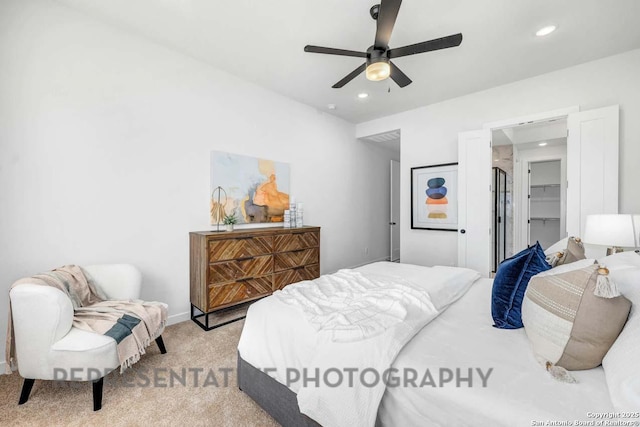 bedroom with a walk in closet, light colored carpet, ceiling fan, and recessed lighting