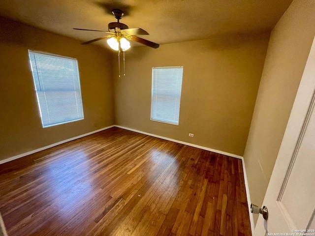 spare room featuring a textured ceiling, wood finished floors, a ceiling fan, and baseboards