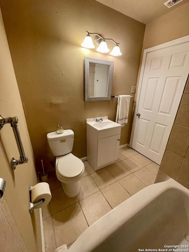 bathroom featuring visible vents, toilet, vanity, tile patterned flooring, and baseboards