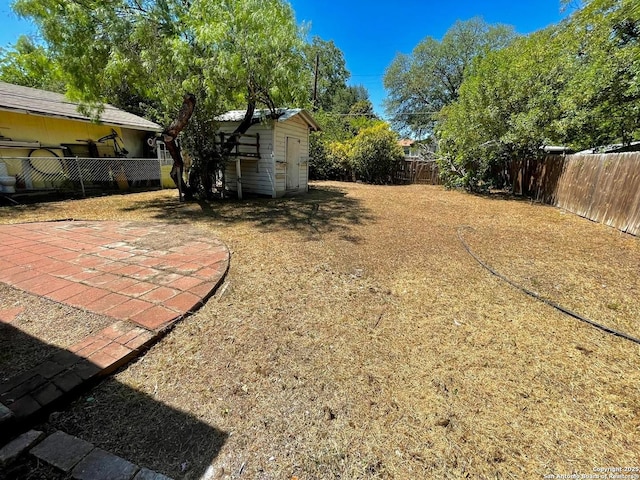 view of yard with a patio, an outdoor structure, and a fenced backyard