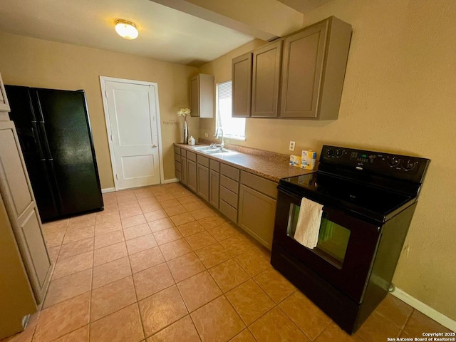 kitchen featuring black appliances, light tile patterned floors, baseboards, and a sink