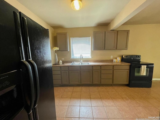 kitchen with light tile patterned floors, light countertops, gray cabinetry, black appliances, and a sink