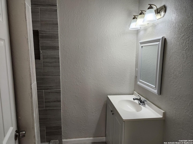 bathroom featuring a textured wall and vanity