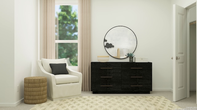 sitting room with baseboards and light colored carpet