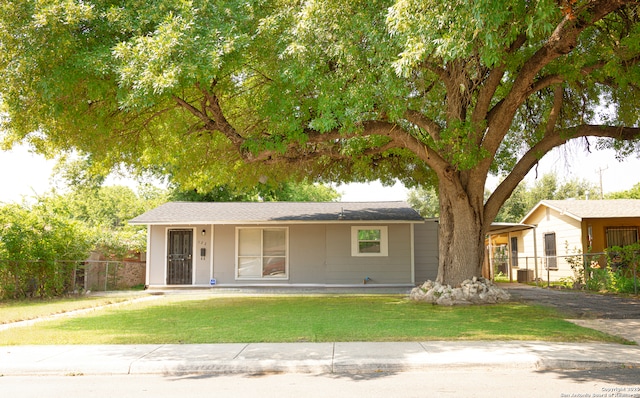 ranch-style home with a front yard and fence