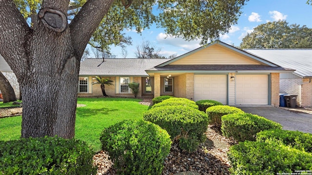 ranch-style home with an attached garage, brick siding, a shingled roof, driveway, and a front lawn