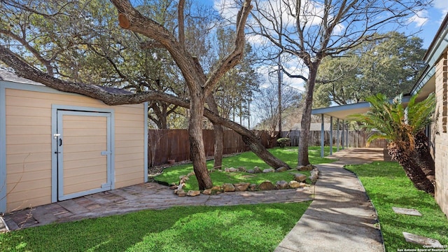 view of yard featuring an outbuilding, a fenced backyard, and a storage unit