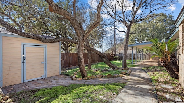 view of yard featuring an outbuilding, a storage unit, and a fenced backyard