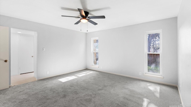 spare room with a healthy amount of sunlight, ceiling fan, and light colored carpet