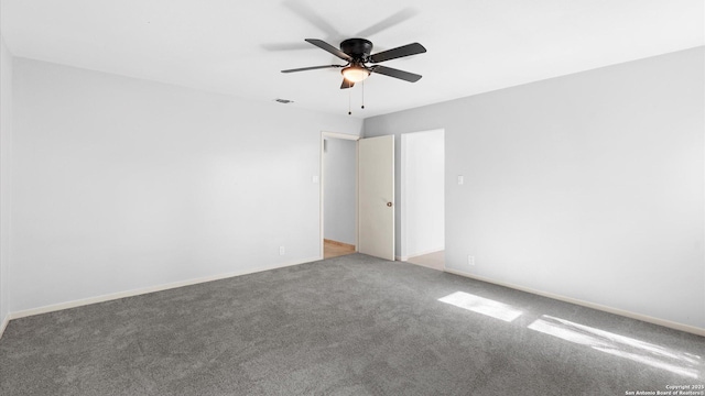 carpeted spare room with visible vents, ceiling fan, and baseboards