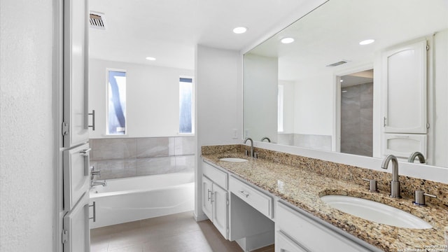 full bath with double vanity, a sink, and visible vents