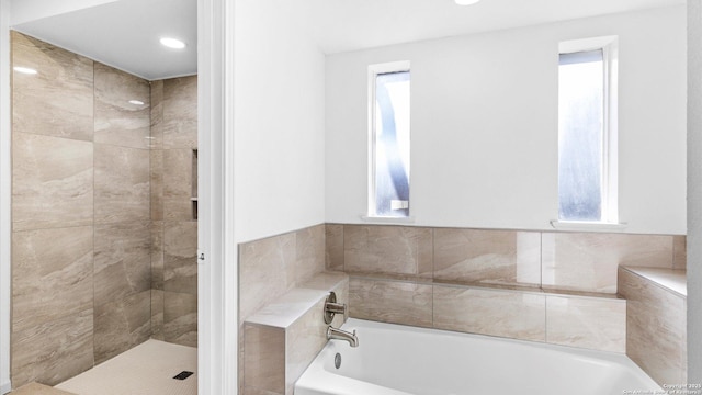 full bathroom with tiled shower, plenty of natural light, and a bath