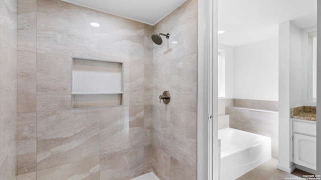 full bath with tiled shower, a garden tub, and vanity