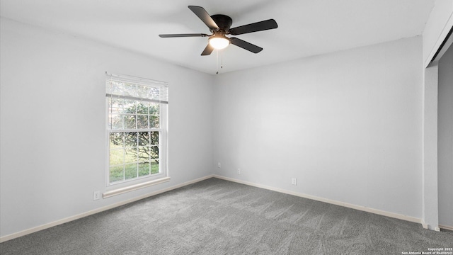 carpeted empty room featuring ceiling fan and baseboards