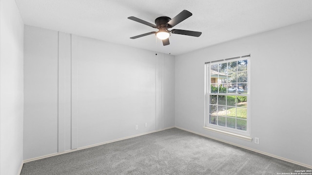 carpeted spare room featuring ceiling fan and a textured ceiling