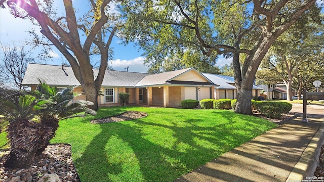 ranch-style home featuring brick siding and a front lawn