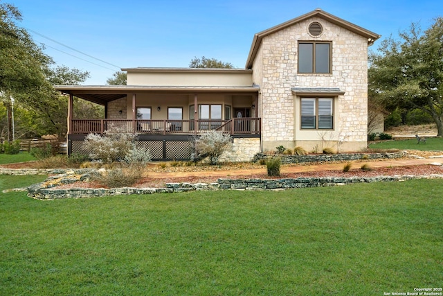 back of house with stone siding and a yard