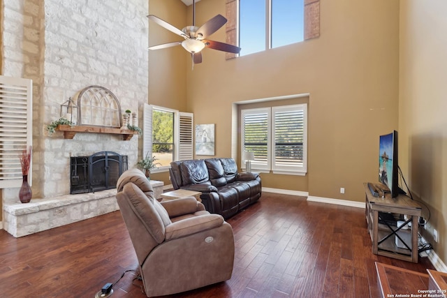 living room with ceiling fan, a fireplace, baseboards, and wood finished floors