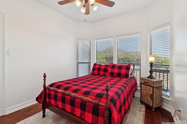 bedroom featuring wood finished floors, a ceiling fan, and baseboards