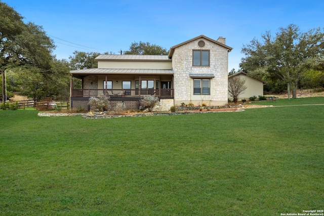 view of front of property with metal roof, stone siding, a front lawn, and a standing seam roof