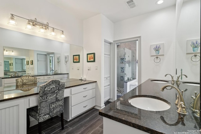 bathroom with a stall shower, visible vents, and a sink