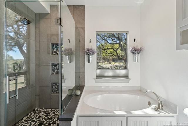 bathroom with a shower stall and a bath