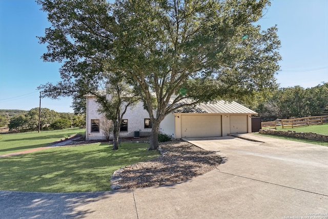 view of front of home with driveway, an attached garage, fence, and a front lawn