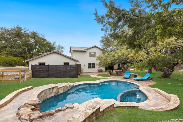 view of pool with a pool with connected hot tub, a lawn, a patio, and fence