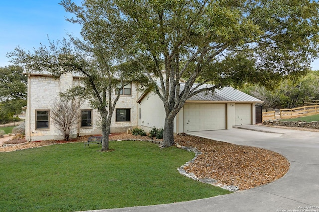 view of front of home featuring a garage, a front yard, stone siding, and concrete driveway