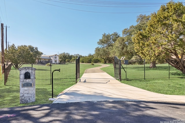 view of property's community featuring a gate, fence, and a lawn