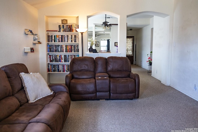 carpeted living room featuring lofted ceiling, ceiling fan, and arched walkways