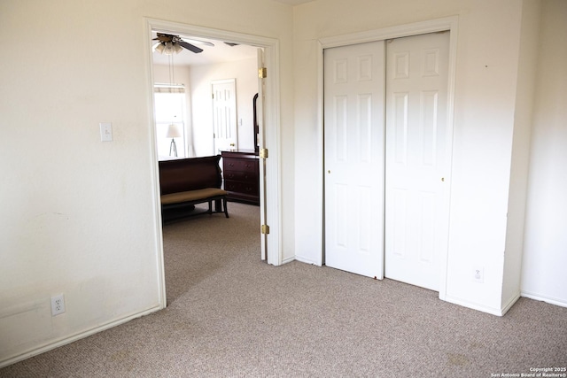 unfurnished bedroom featuring carpet floors, a closet, and baseboards