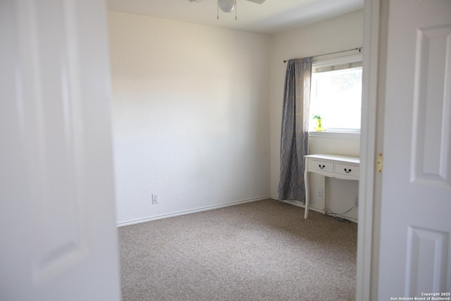 unfurnished room featuring carpet, a ceiling fan, and baseboards