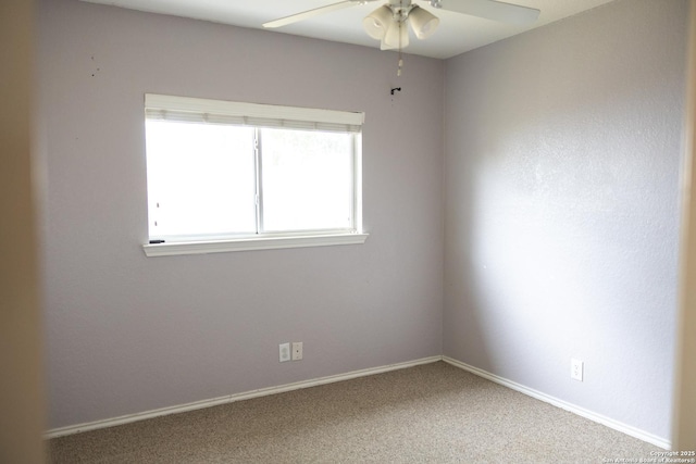 carpeted empty room featuring ceiling fan and baseboards